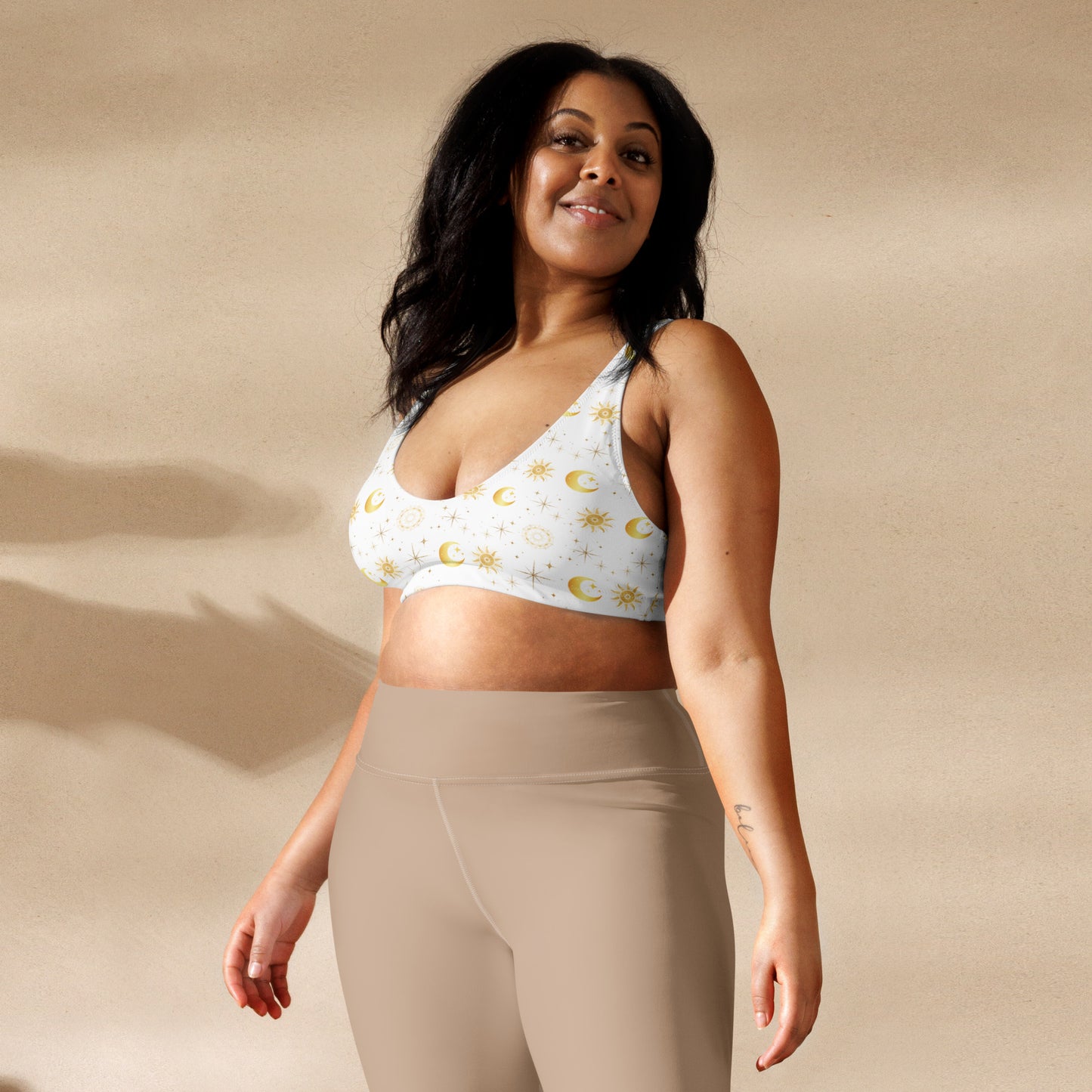 Plus sized woman in a white and gold celestial bikini top