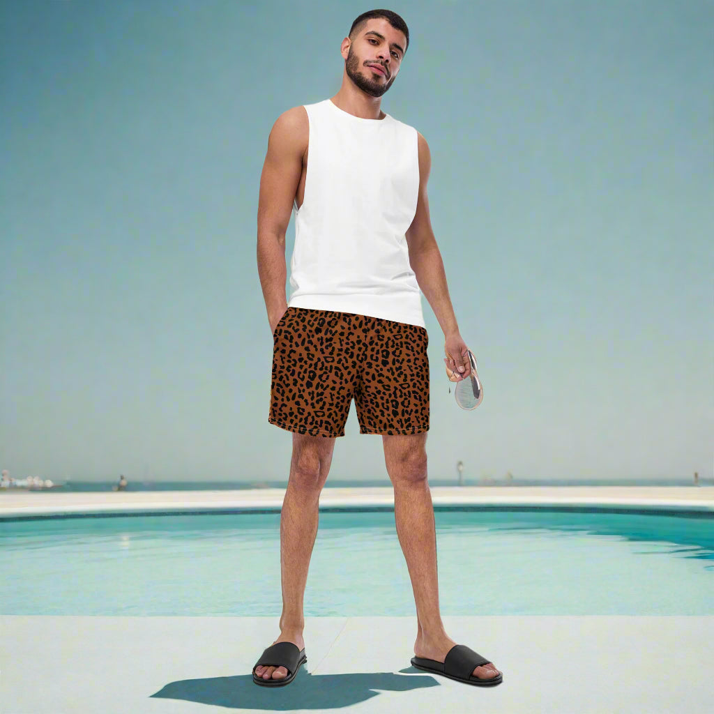 man standing in front of a pool with a dark brown and black cheetah print bathing suit.