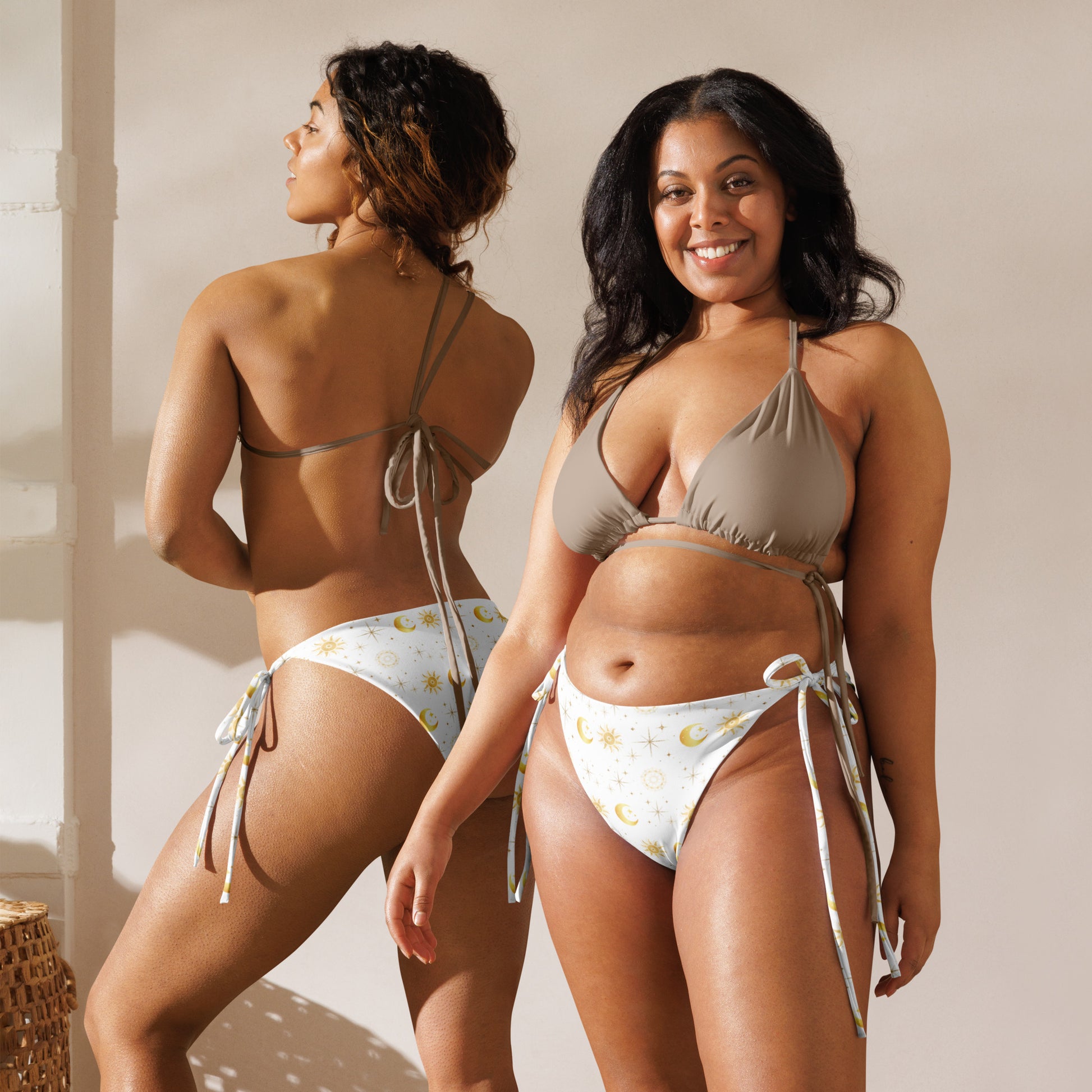 2 Women wearing a white and gold string bikini bottom