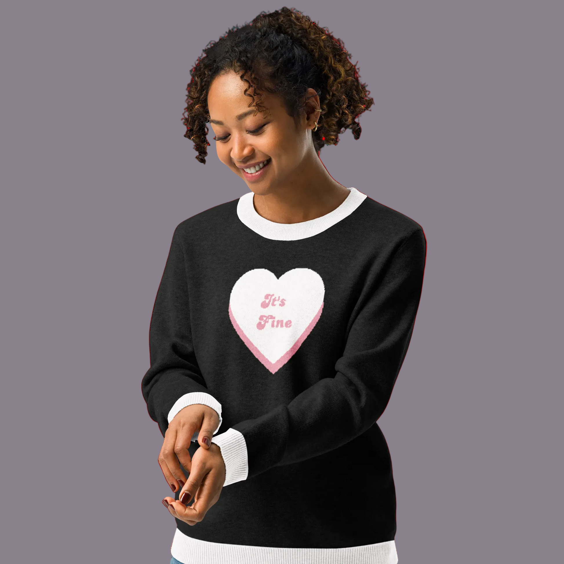 Woman wearing a black sweater with a pink heart design