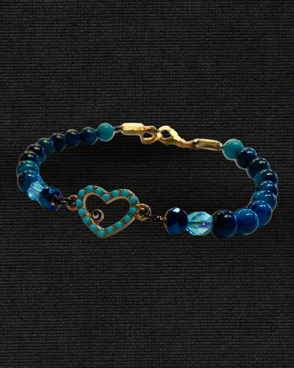 evil eye Bracelet with blue beads and a heart-shaped clasp on a black background